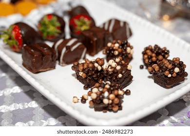 Plate full of an assortment of desserts such as cookies, chocolate covered strawberries, mini cannoli and more. - Powered by Shutterstock