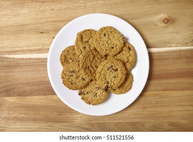 A Plate Full Of Freshly Baked Oatmeal And Raisin Cookies On A Wooden Kitchen Counter Background