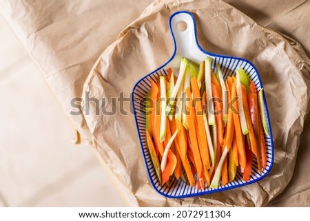 Plate full of thinly cut vegetables on a kitchen table