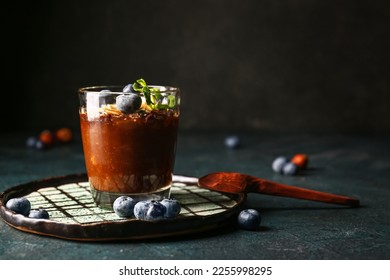 Plate with glass of delicious chocolate pudding, blueberry and almond on black table - Powered by Shutterstock