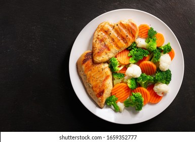 Plate Of Grilled Chicken With Vegetables On A Dark Background, Top View