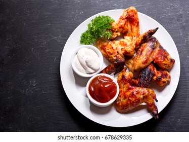 Plate Of Grilled Chicken Wings On Dark Background, Top View