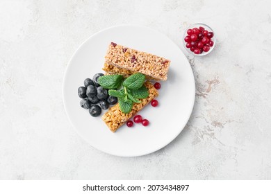 Plate With Healthy Cereal Bars And Berries On Light Background