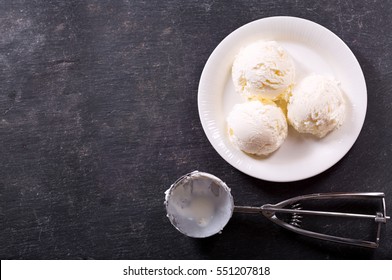 plate of ice cream scoops on dark background, top view with copy space.