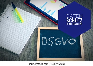 Plate with the inscription DSGVO (Datenschutzgrundverordnung) in English GDPR (General Data Protection Regulation) with tablet and block and datenschutzbeauftragter in english data protection officer