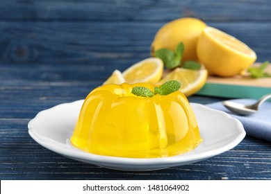 Plate with lemon jelly and mint on blue wooden table
