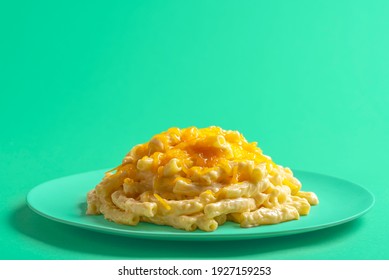 Plate With Mac And Cheese Isolated On A Green Background. Macaroni With Bechamel Sauce And Melted Cheddar Cheese On A Green Plate.