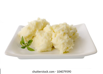A plate of mashed potato and a sprig of basil, isolated on white