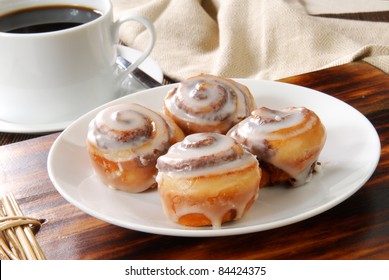 A Plate Of Mini Cinnamon Rolls And A Cup Of Black Coffee