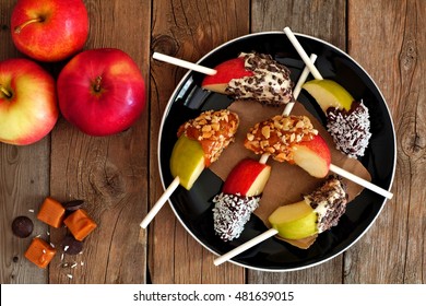 Plate Of Mixed Sweet Caramel And Chocolate Dipped Apple Slices, Overhead Scene On Rustic Wood