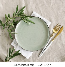 Plate Mockup On Minimal Table Place Setting With Cutlery, Olive Branch On Beige Linen  Tablecloth.  Space For Text. Wedding Invitation, Menu.