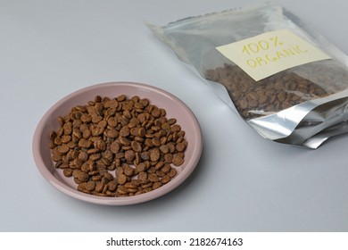 Plate And Pack Of Organic Kibble On Light Background