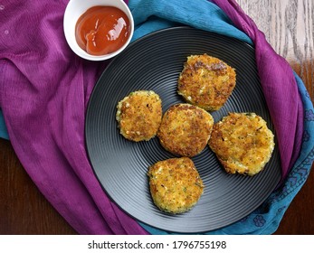 A Plate With Paneer Cutlet, A Breaded Crispy Patty With Paneer Cheese And Potato.
