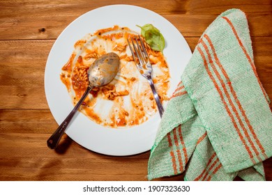 Plate Of Pasta With Sauce Finished And Dirty On A Wooden Table. Top View