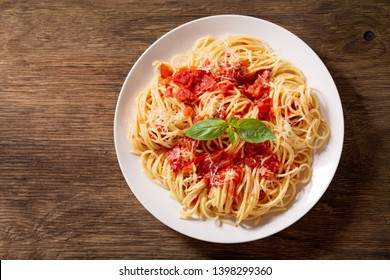 Plate Of Pasta With Tomato Sauce On Wooden Table, Top View