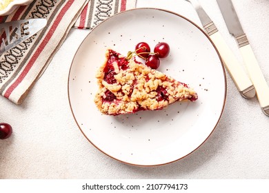Plate with piece of tasty cherry pie on light background