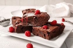 Plate With Pieces Of Raspberry Chocolate Brownie On White Tile Background
