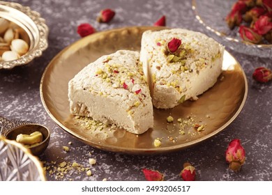 Plate with pieces of tasty Tahini halva on grunge background