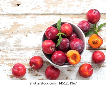 The plate with plums on white wood board. Top view. Fruits background with space for text. Agriculture, Gardening, Harvest Concept. - Powered by Shutterstock