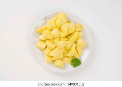 plate of raw diced potatoes on white background