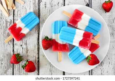 Plate Of Red, White And Blue Summer Fruit Popsicles. Overhead View Table Scene On A White Wood Background.