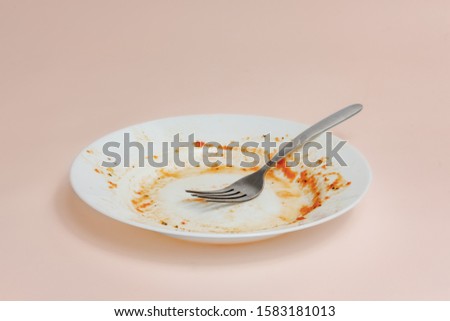 A plate with rests of tomato sauce in it. Unwashed dishes illustration, filthy plate on light background