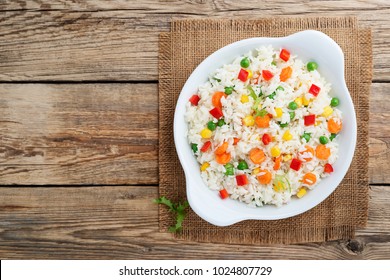 A Plate Of Rice With Vegetables On Wooden Table.top View.