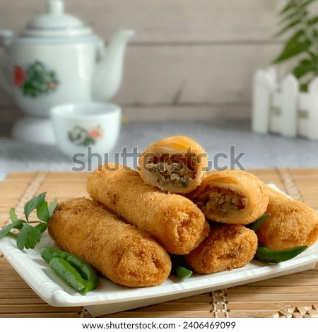A plate of risoles with green chilli in selective background