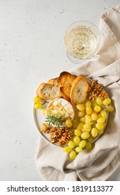 Plate With Roast Camembert And Slice Of Bread And Brunch Of Green Grape And Wine In Glass, Copy Space, Top View