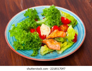 Plate Of Salad With Greens, Tomatoes, Baked Trout Fillet And Savory Sauce