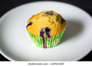 A Plate With A Single Blueberry Muffin Close Up