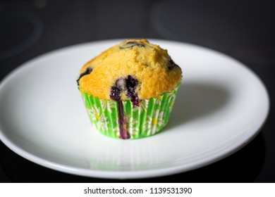 A Plate With A Single Blueberry Muffin Close Up