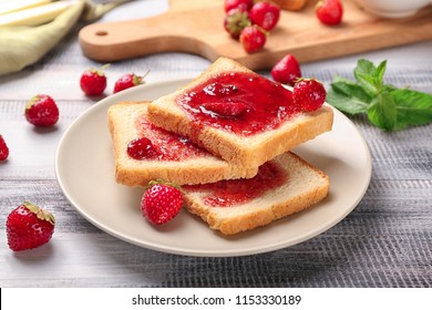 Plate with slices of bread and delicious strawberry jam on wooden table - Powered by Shutterstock