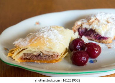 Plate Of Sour Cherry Strudel On A Wooden Table