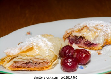 Plate Of Sour Cherry Strudel On A Wooden Table