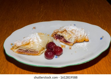 Plate Of Sour Cherry Strudel On A Wooden Table