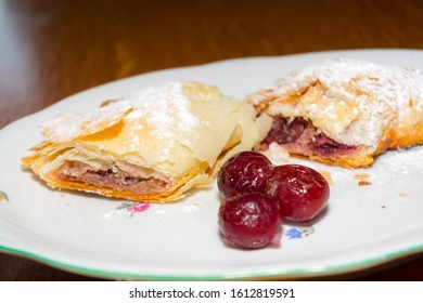 Plate Of Sour Cherry Strudel On A Wooden Table