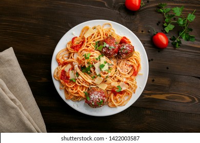 Plate Of Spaghetti With Meatballs, Parmesan And Tomato Sauce On A Rustic Wooden Table. Tasty Italian Pasta Food. Top View Shot Directly Above.