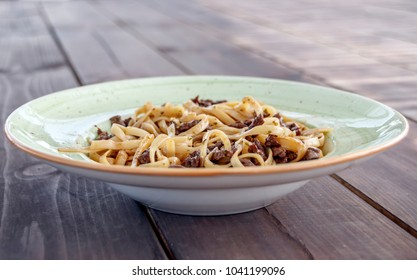 Plate With Spaghetti With Pieces Of Meat On A Table Of Wooden Boards Side View