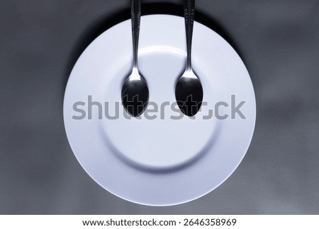 Plate and spoon forming a smiley face emoji, creative food concept, kitchen concept background