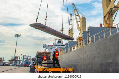 plate of steel slab being lifting by the ship crane, loading discharging operation for transfer the cargo shipment in export and import, works by stevedore labor in charge on jetty port terminal