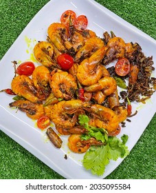 A Plate Of Stir-fry Butter Prawn With Some Turmeric And Cherry Tomatoes.