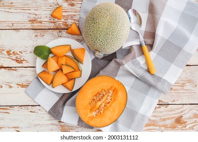 Plate With Sweet Cut Melon On Wooden Background