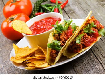 plate with taco, nachos chips and tomato dip - Powered by Shutterstock