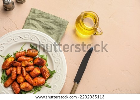 Plate with tasty baked carrots and pitcher of oil on color background Imagine de stoc © 