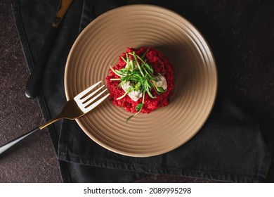 Plate with tasty beet risotto on dark background