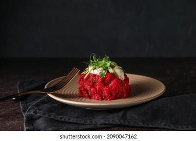 Plate with tasty beet risotto on dark background