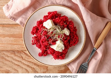Plate with tasty beet risotto on wooden background