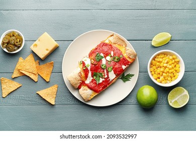 Plate With Tasty Cooked Enchilada And Products On Table