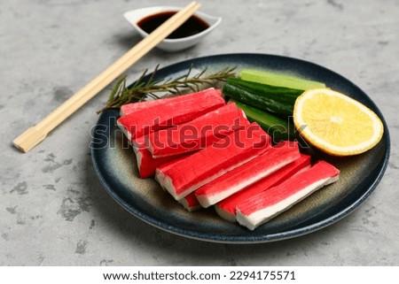 Plate with tasty crab sticks on grunge background